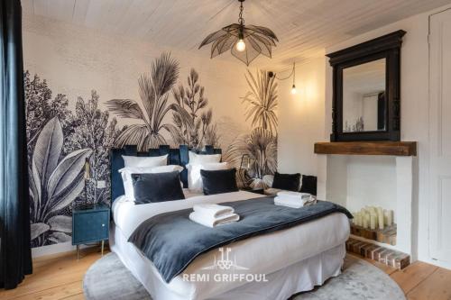 une chambre avec un grand lit et un mur avec des plantes dans l'établissement L'Atelier d'Éléa 4 Terrace - Industrial-chic in the heart of Honfleur, à Honfleur