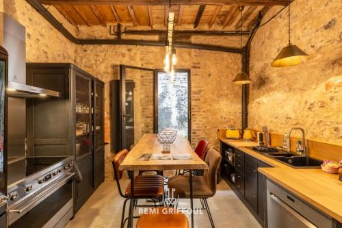 une cuisine avec une table en bois et quelques chaises dans l'établissement L'Atelier d'Éléa 4 Terrace - Industrial-chic in the heart of Honfleur, à Honfleur