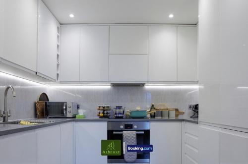 a white kitchen with white cabinets and appliances at One Bedroom Apartment By Arhouse Apartments Short Lets & Serviced Accommodation Kingston With Free WiFi in Kingston upon Thames