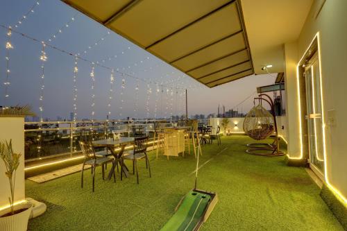 a patio with a table and chairs on a balcony at Hotel GreySky Near Medanta Hospital in Gurgaon