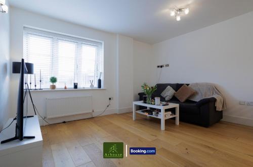 a living room with a black couch and a window at One Bedroom Apartment By Arhouse Apartments Short Lets & Serviced Accommodation Kingston With Free WiFi in Kingston upon Thames