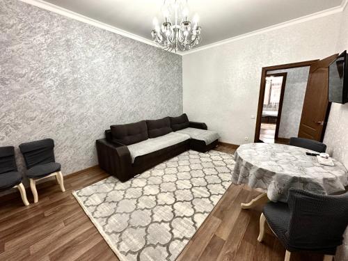 a living room with a couch and a table at Майлина 10 аэропорт in Turksib