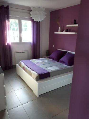 - une chambre avec un lit aux murs violets et des rideaux violets dans l'établissement Ville en Corse sur la Côte Est, à Santa-Maria-Poggio