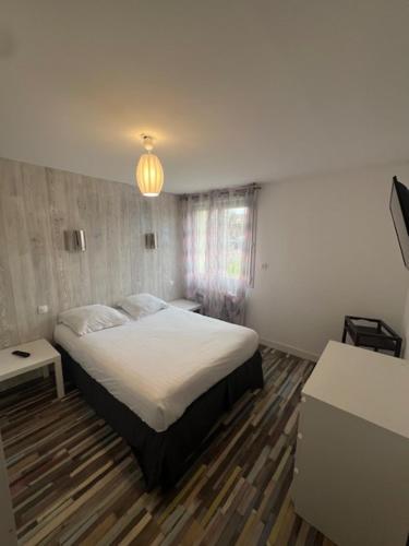 une chambre avec un lit et un lustre dans l'établissement Maison du manoir, à Bénouville