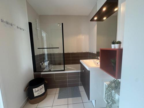 a bathroom with a shower and a sink and a tub at Stunning T2 pool box-Meyzieu Gare-Stade-Eurexpo in Meyzieu