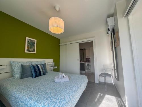 a bedroom with a bed and a green wall at Stunning T2 pool box-Meyzieu Gare-Stade-Eurexpo in Meyzieu