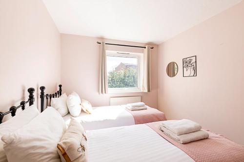 a bedroom with two beds and a window at Quiet and cosy 2-bed in Wimbledon in London