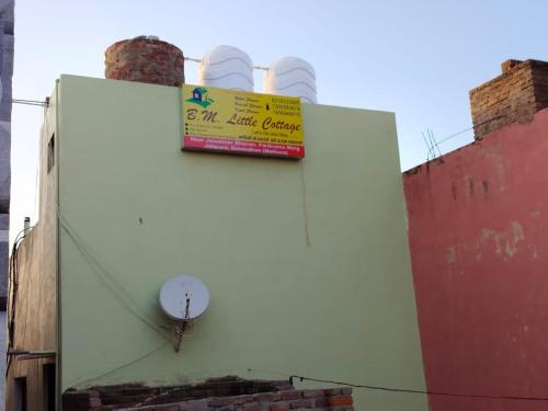 a sign on the side of a building at B M little cottage in Mathura