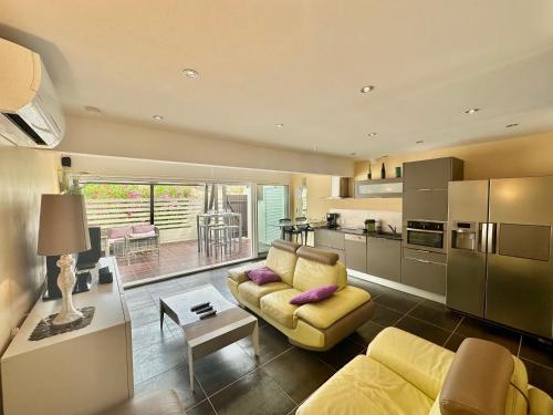 un salon avec un canapé jaune et une cuisine dans l'établissement Villa n47 luxe Port Nature 1 Village Naturiste, au Cap d'Agde