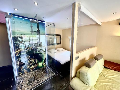 Cette chambre dispose d'une douche en verre avec un lit et un lit. dans l'établissement Villa n47 luxe Port Nature 1 Village Naturiste, au Cap d'Agde