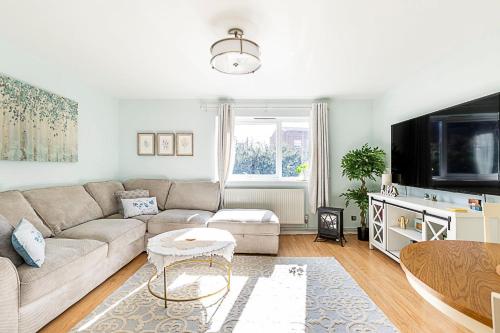 a living room with a couch and a tv at Quiet and cosy 2-bed in Wimbledon in London