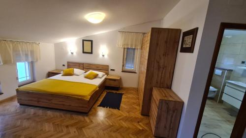a bedroom with a large bed and a bathroom at Apartments Ivanovski in Rab