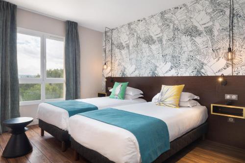 a hotel room with two beds and a large window at Hôtel Birdy by Happyculture in Aix-en-Provence