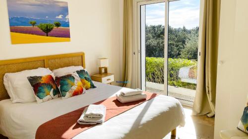 ラ・ロンド・レ・モールにあるLes Romarinsの大きな窓のあるベッドのある寝室