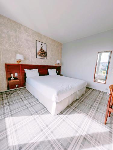 a bedroom with a large white bed and a window at ibis Styles Le Havre Centre in Le Havre