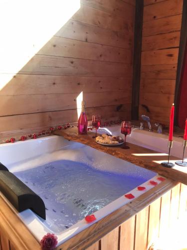 a jacuzzi tub in a room with wine glasses at The Reo's Suit in Çayırdüzü