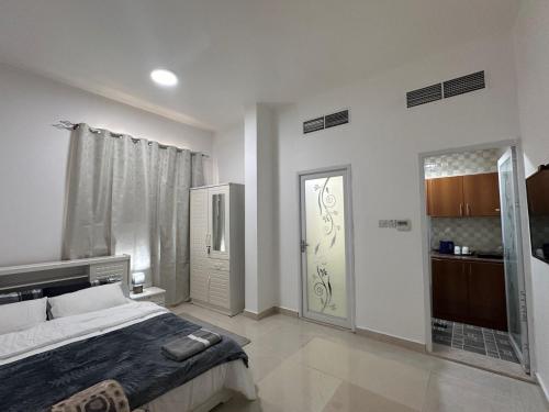a bedroom with a bed and a sliding door at Cozy Studio Retreat in Al Ain in Al Ain