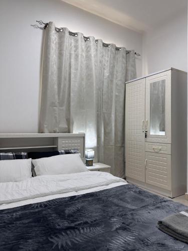 a bedroom with a large bed and a dresser at Cozy Studio Retreat in Al Ain in Al Ain