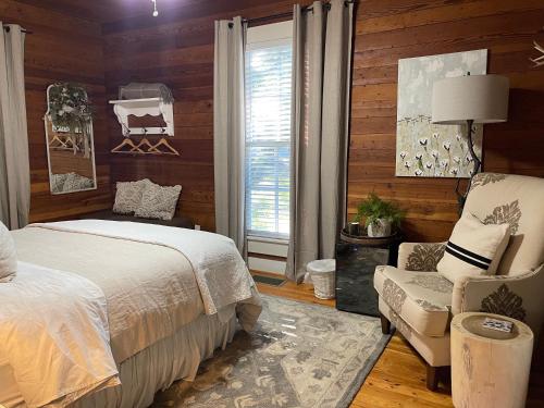 a bedroom with a bed and a chair and a window at Yellow Daisy Bed and Breakfast in Dahlonega