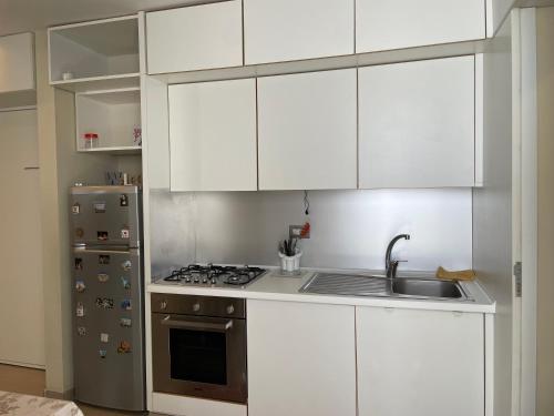 a kitchen with white cabinets and a sink and a refrigerator at Casa Sermoneta in Naples
