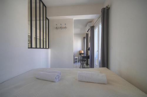 - une chambre blanche avec un lit et 2 oreillers dans l'établissement STUDIO fonctionnel et confortable A0B204, à Cannes