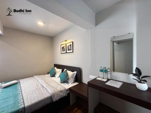 a bedroom with a bed and a vanity with a mirror at Bodhi Inn Homestay in Darjeeling