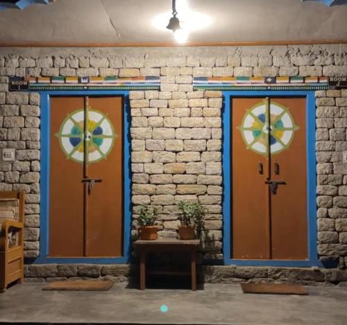 two doors in front of a brick wall with a table at Daragaon Retreat (Gurung Homestay) in Pelling