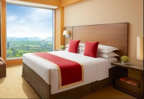 a bedroom with a large bed with a large window at hotel radiant in Mumbai