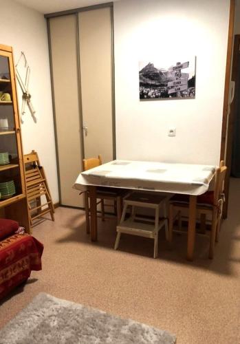 une table et des chaises dans une pièce avec une table dans l'établissement Studio 4 personnes, Les Rochers Blancs, La joue du loup, à Saint-Étienne-en-Dévoluy