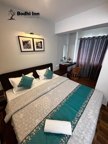 a bedroom with a large bed with green and white sheets at Bodhi Inn Homestay in Darjeeling