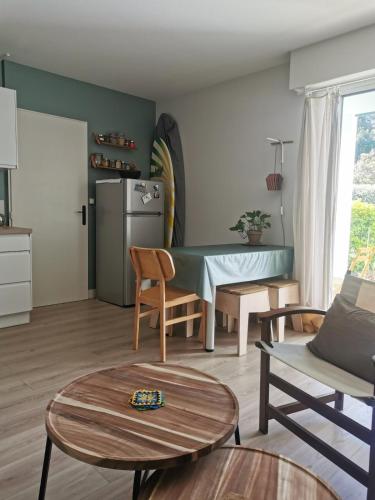 un salon avec une table et une cuisine dans l'établissement Charmant appartement au calme, à Biarritz