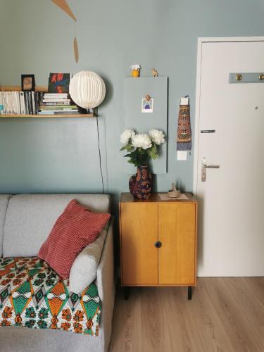 une chambre avec un lit et une table avec un vase de fleurs dans l'établissement Charmant appartement au calme, à Biarritz