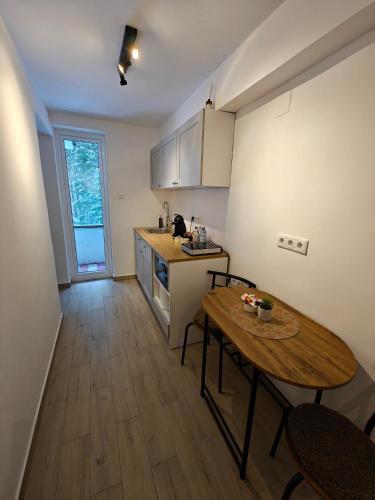 a kitchen with a wooden table and a table and chairs at Red Lake Apartman in Lacu Rosu