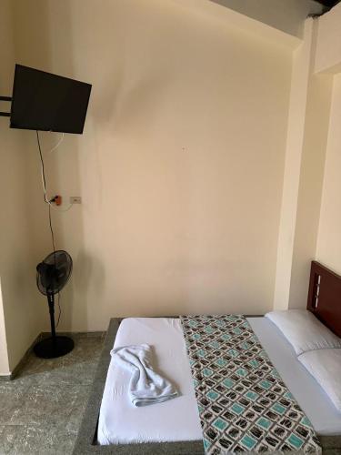 a bedroom with a bed with a towel on it at Hotel Primavera in Floridablanca