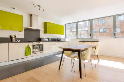 une cuisine avec des armoires jaunes, une table et des chaises dans l'établissement Lovely apartment dowtown with terrace and parking, à Bordeaux