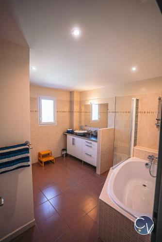 une salle de bain avec une baignoire et un lavabo dans l'établissement Le Nid des Grands Ducs, Villa avec piscine privée, à Issirac