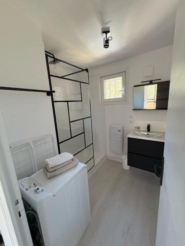 une salle de bain blanche avec un lavabo et des toilettes dans l'établissement T2 tout confort et moderne, climatisé avec balcon et parking, à 10 min du port et de la plage, à Sanary-sur-Mer