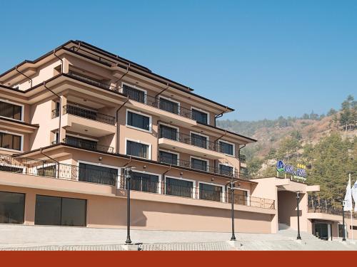 a large building with balconies on the side of it at Park Hotel and SPA Vella Hills in Velingrad