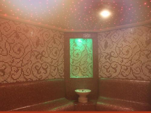 a bathroom with a toilet and a window at Park Hotel and SPA Vella Hills in Velingrad