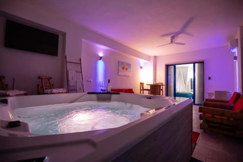 a large bath tub in a room with purple lighting at Dreams in the Suite in Inverno in Torre Squillace