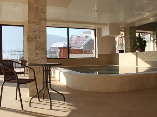 a house with a swimming pool and a table and chairs at Park Hotel and SPA Vella Hills in Velingrad