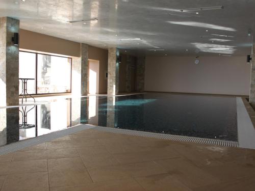 a large swimming pool in a building with a ceiling at Park Hotel and SPA Vella Hills in Velingrad