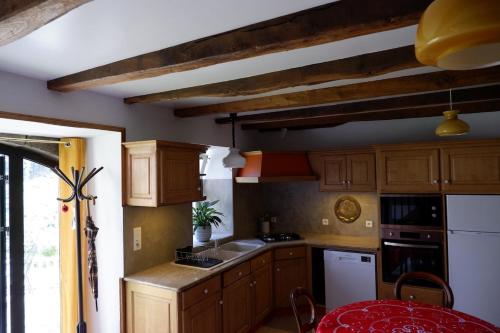 une cuisine avec des armoires en bois et une table à l'intérieur dans l'établissement Nature, Calme et Volupté, Maison Félicie, à Girgols