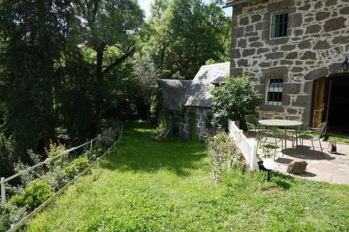 una casa in pietra con tavolo e sedie nel cortile di Nature, Calme et Volupté, Maison Félicie a Girgols
