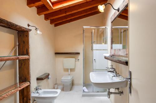 a bathroom with two sinks and a toilet at Borgo Olivo by Wonderful Italy in Puegnano del Garda