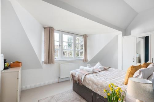a white bedroom with a bed and a window at The Vicarage Tooting, SW17 in London