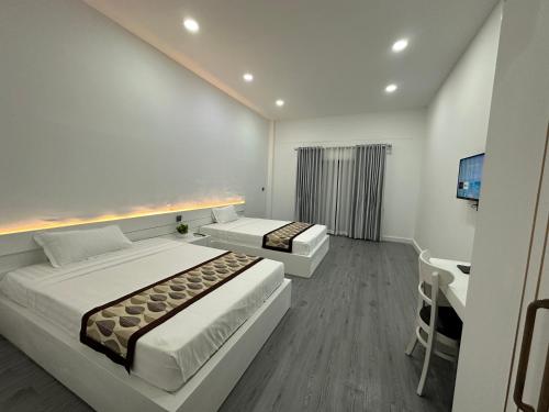 a hotel room with two beds and a television at The Aura Residence in Sihanoukville