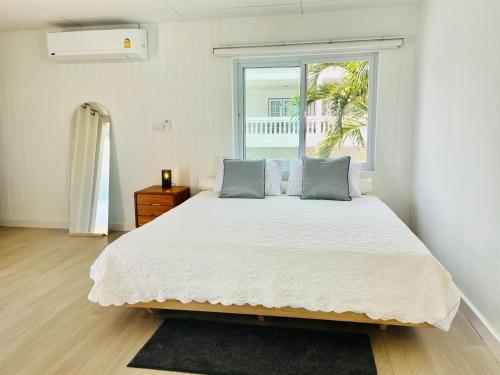 Un dormitorio con una cama grande con ventana. en Peaceful Hideaway with Stunning View Beach Access, en Mae Nam