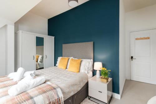 a bedroom with a large bed with a blue wall at The Vicarage Tooting, SW17 in London