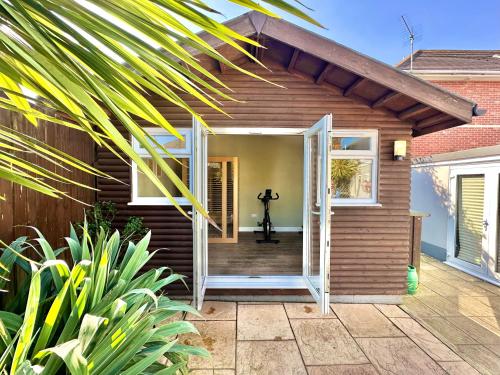 a house with a door open to a porch at Luxurious Retreat - Hot Tub - Pool Table - Gym - Sauna - Cinema Room - Free Parking - WiFi - Close to Beach in Bournemouth